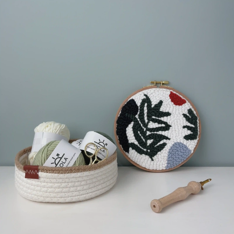 Punch Needle Kit Organization - Wild Leaves Embroidery Supplies Punch needle embroidery kit with wild leaves design, organized yarn supplies in woven basket, and wooden punch needle tool