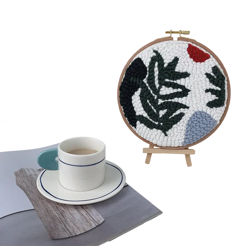 Finished punch needle botanical hoop art with green leaves and red accents, perfect beginner craft project display setup