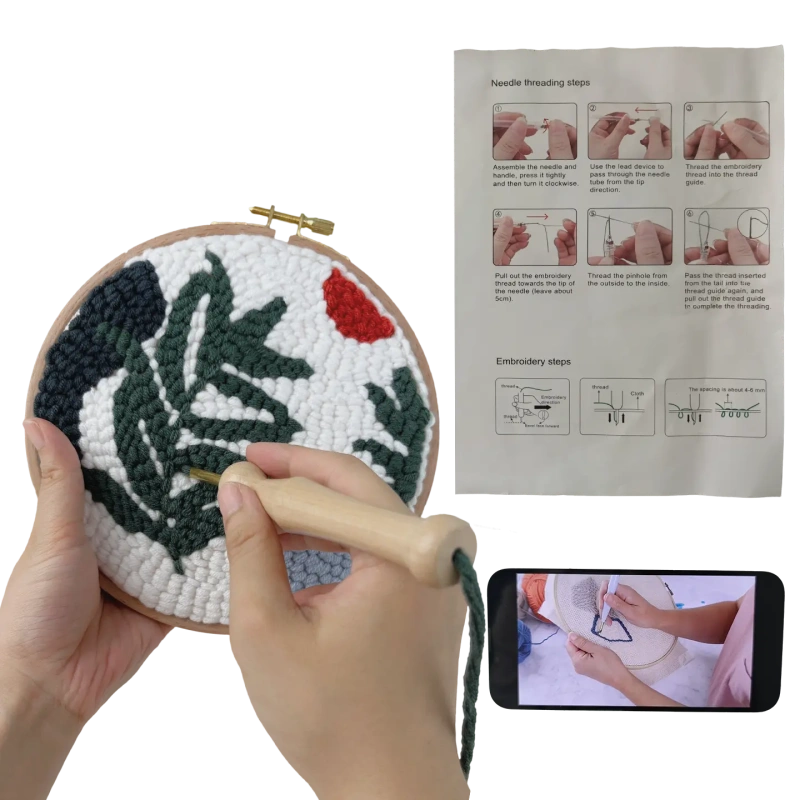 Hands working on punch needle project with instruction manual and video tutorial, perfect for beginners learning