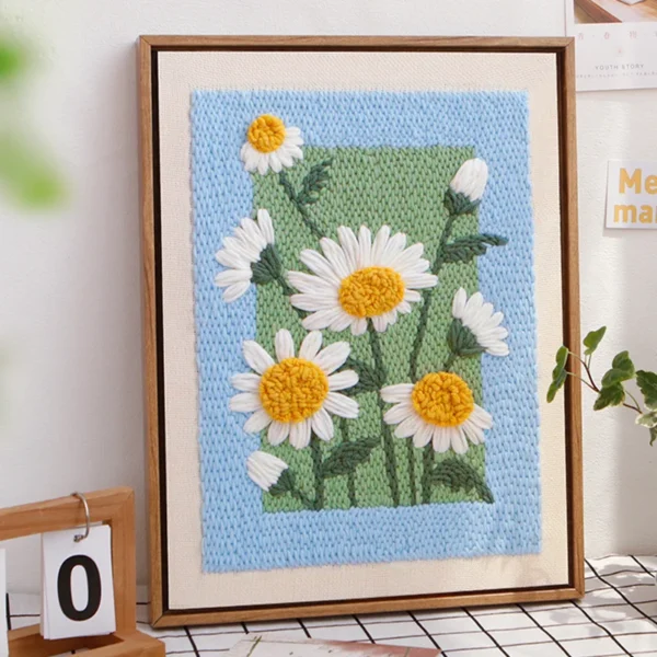 Framed Daisy Punch Needle Artwork — A Bloom of Handmade Warmth Framed punch needle daisy wall art with white and yellow flowers, displayed on a wall.