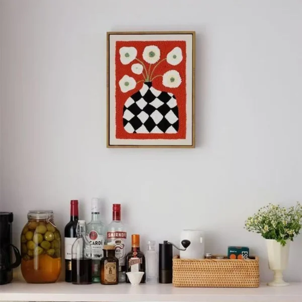 DIY Wall Decor Punch Needle Kit Black & White Checkered Vase Modern Art DIY wall decor punch needle art showing black checkered vase with white flowers on red fabric, framed and displayed above bar area