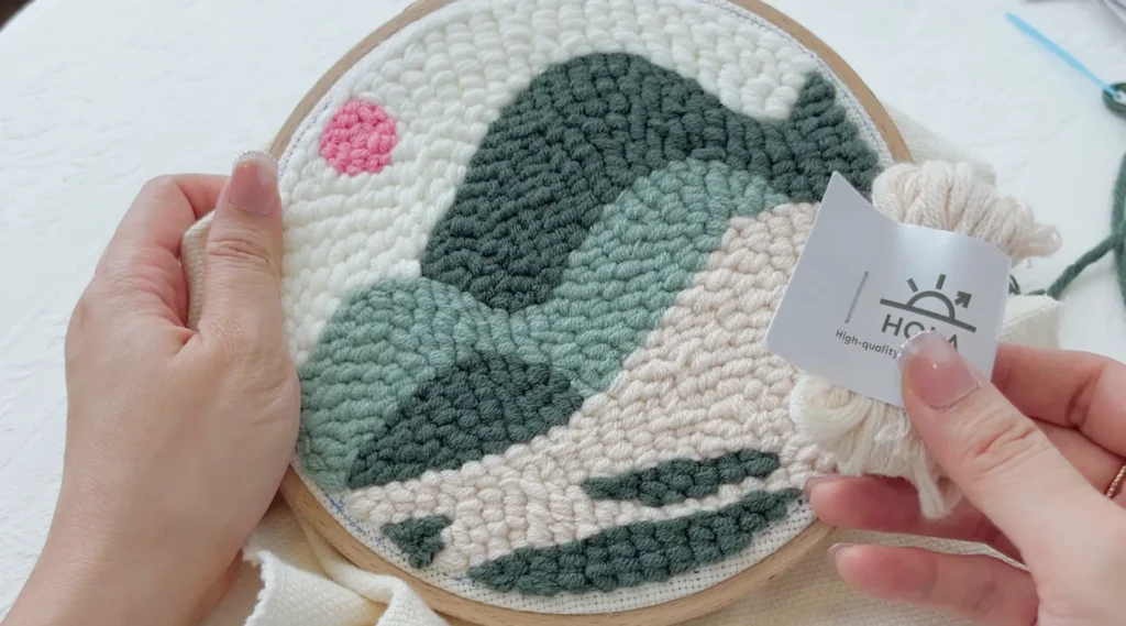 Selecting a matching yarn color for hoop edge finishing using leftover yarn from the kit.