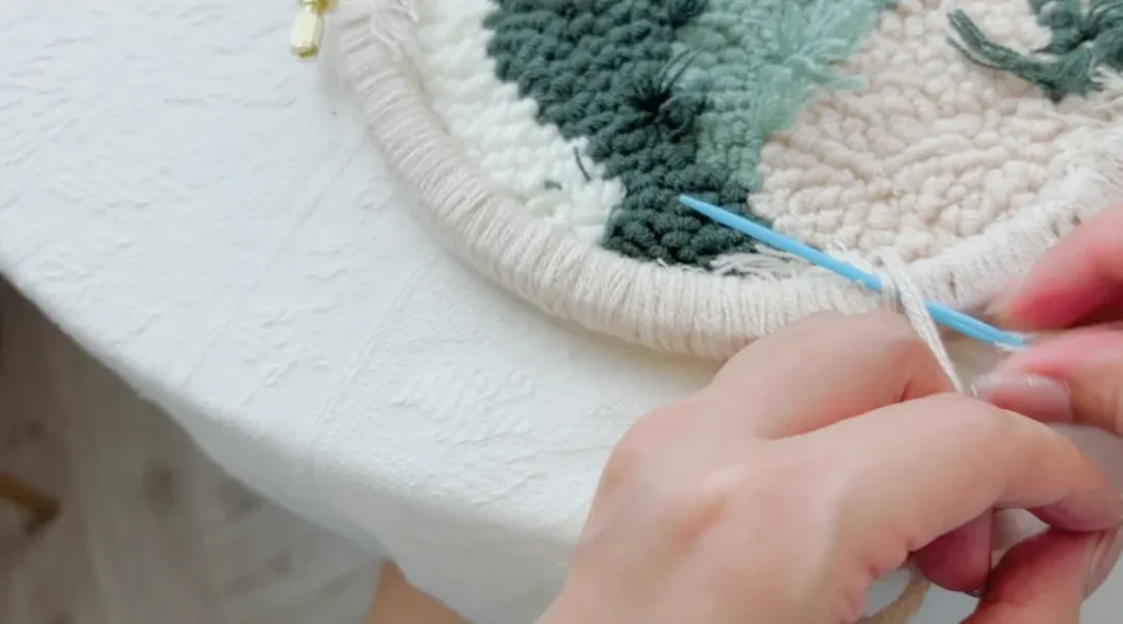 Passing the needle through nearby stitches to secure the ending yarn.