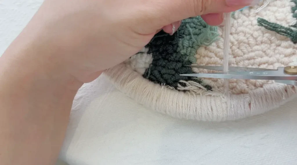 Trimming excess yarn after securing the final knot.