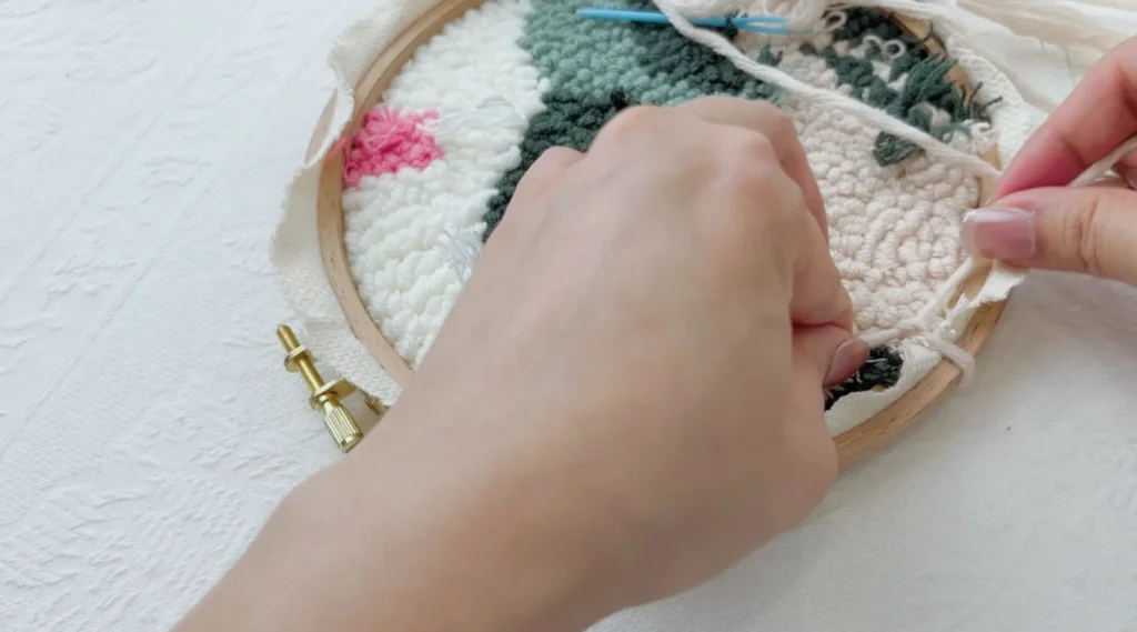 Pulling the yarn tight and fixing it with a double cross knot on the back.