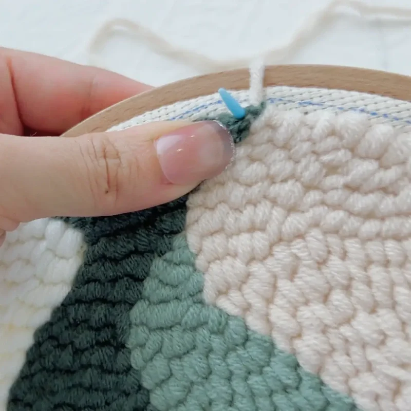 Making the second stitch right next to the first stitch along the hoop edge.