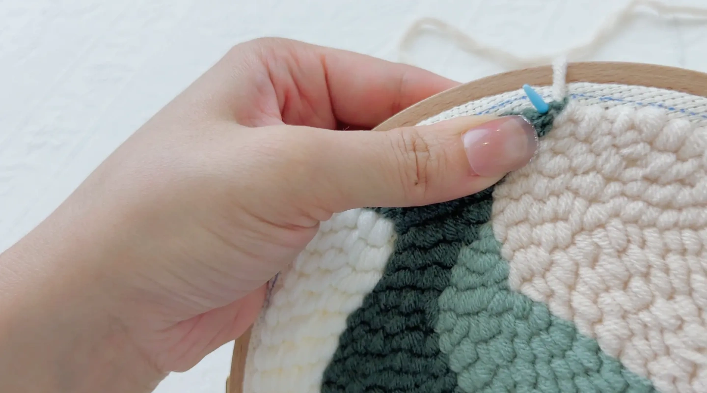 Making the second stitch right next to the first stitch along the hoop edge.