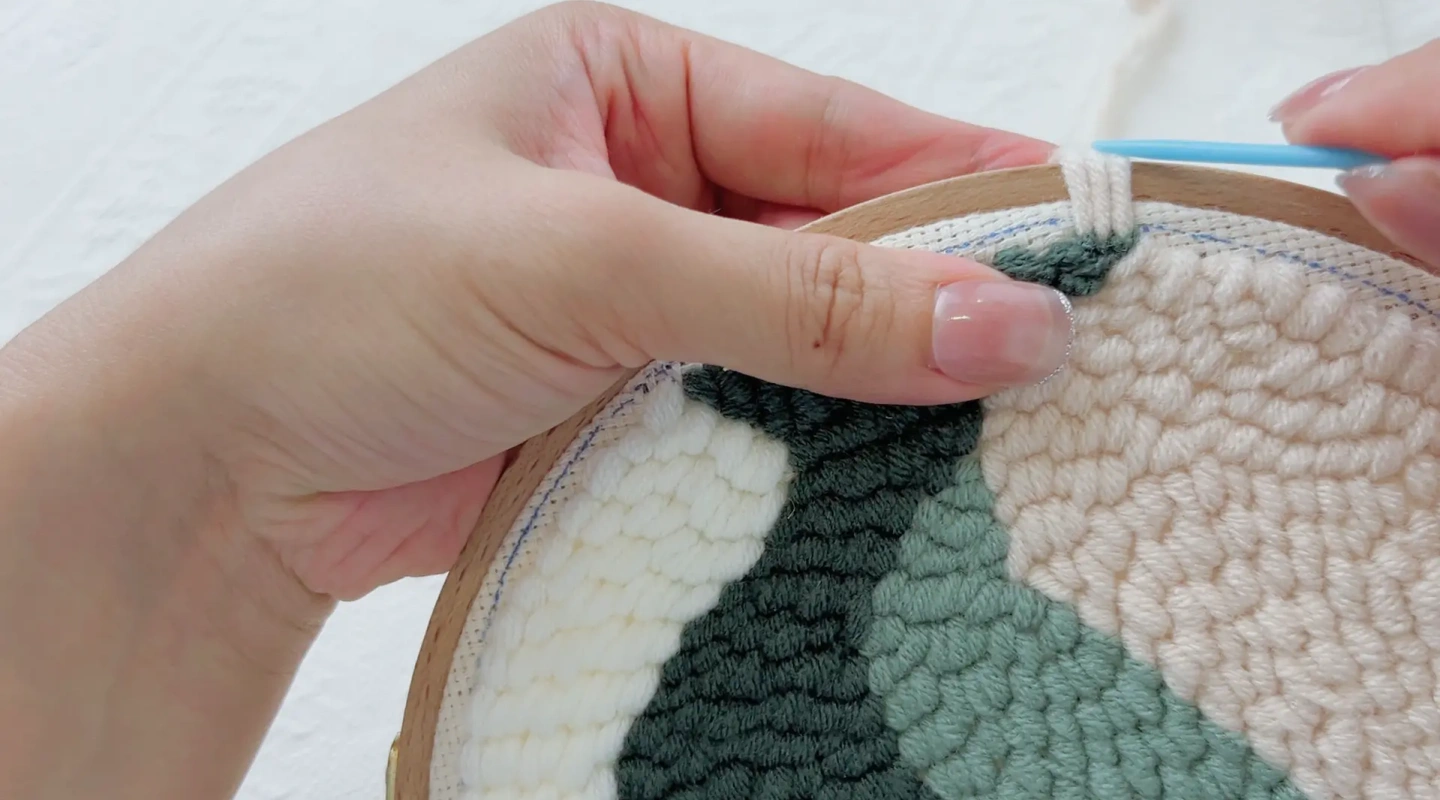 Stitching tightly along the hoop edge with connected loops and no gaps.