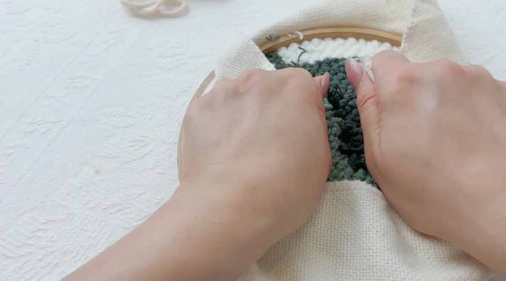 Pulling the base fabric toward the center from the back to keep the front surface smooth.