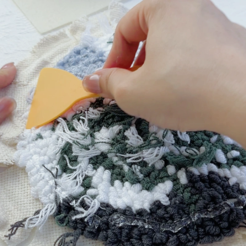 Spreading glue evenly using a plastic scraper.
