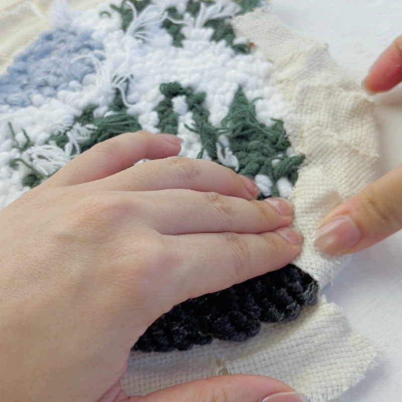 Attaching the base fabric pieces to the back of the embroidery one section at a time in a consistent order.