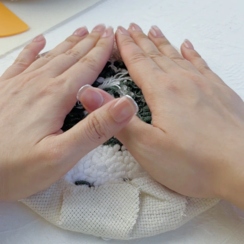 Pressing firmly on the glued fabric area to secure adhesion.