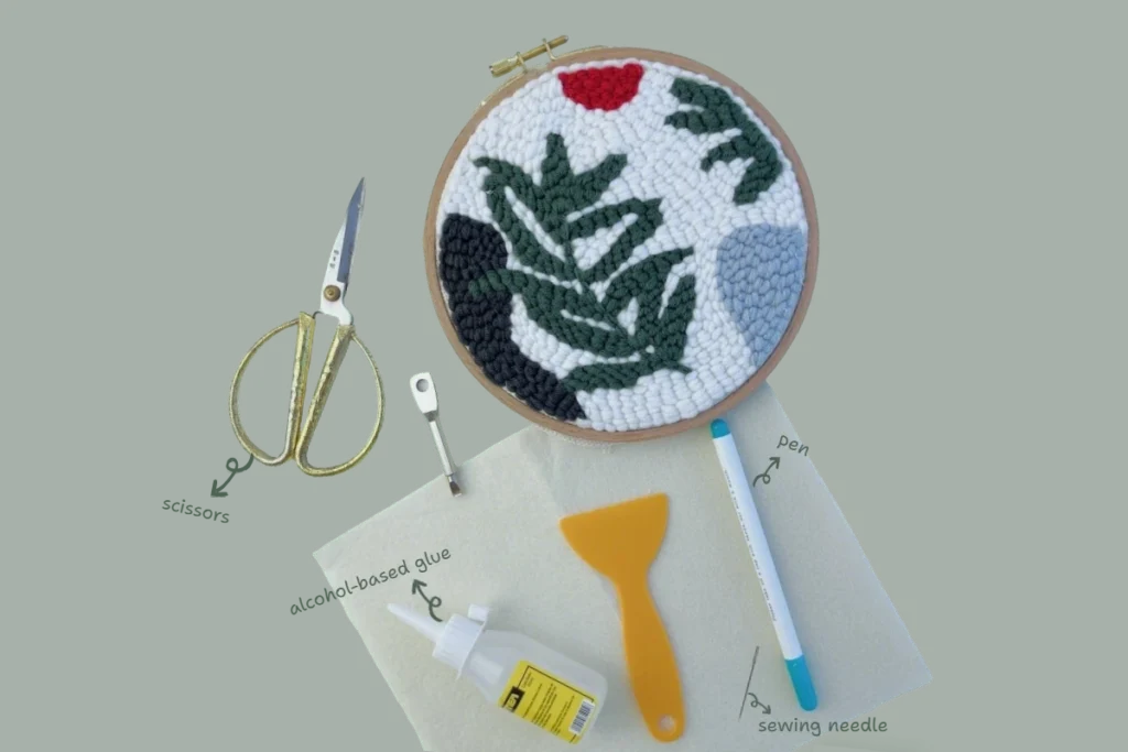 Materials needed to turn a finished punch needle hoop piece into a heat-resistant trivet, including tools and felt backing.