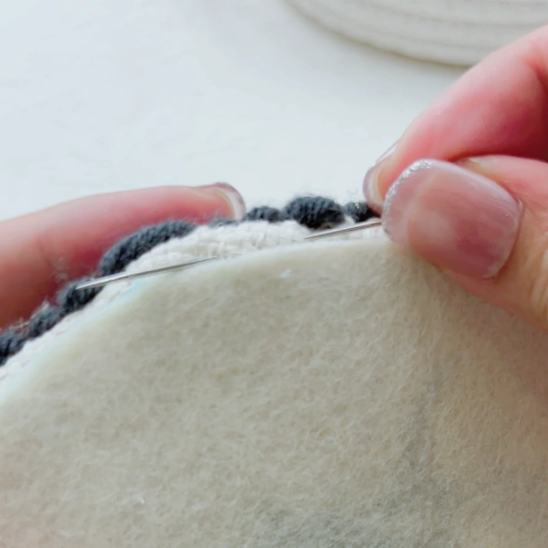 Starting the first stitch horizontally through the edge of the embroidery back.