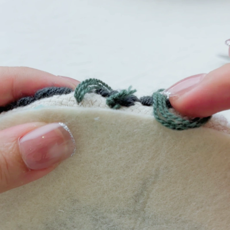 Pulling the yarn through after the first horizontal stitch.