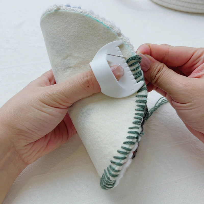 Stitching evenly around the edge using the gauge as a guide.