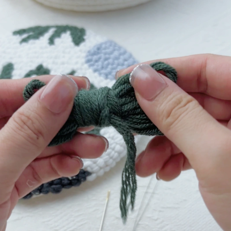 Selecting dark green yarn from leftover yarn in the hoop kit.