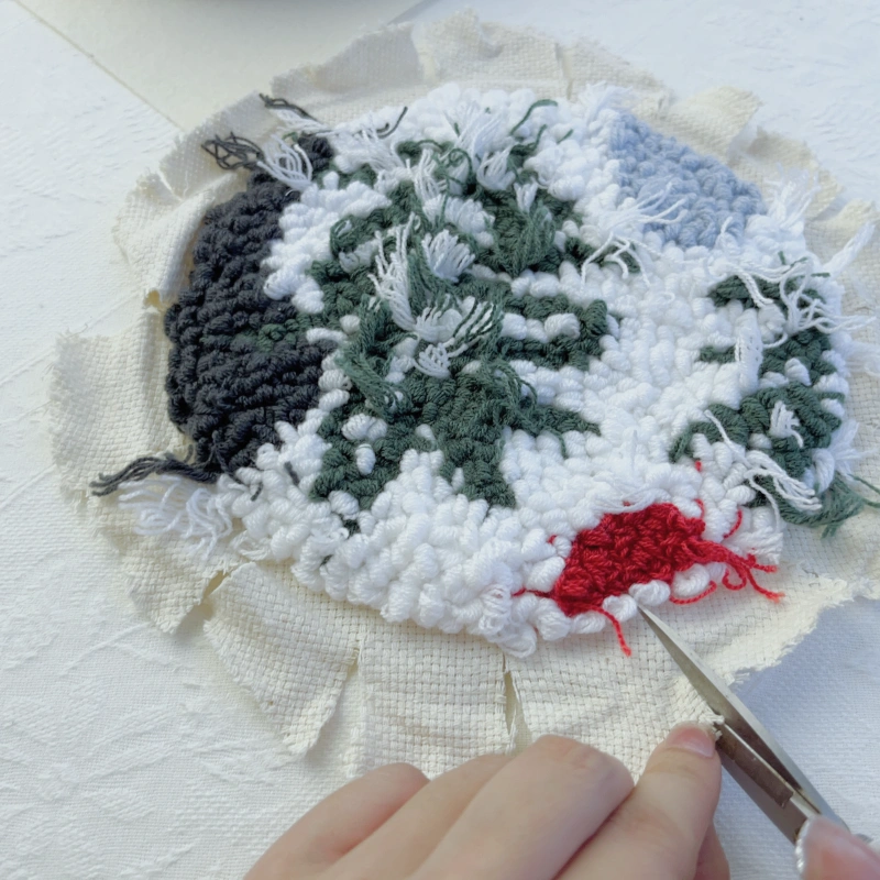 Cutting the base fabric edge into radial sections after removing the embroidery piece.