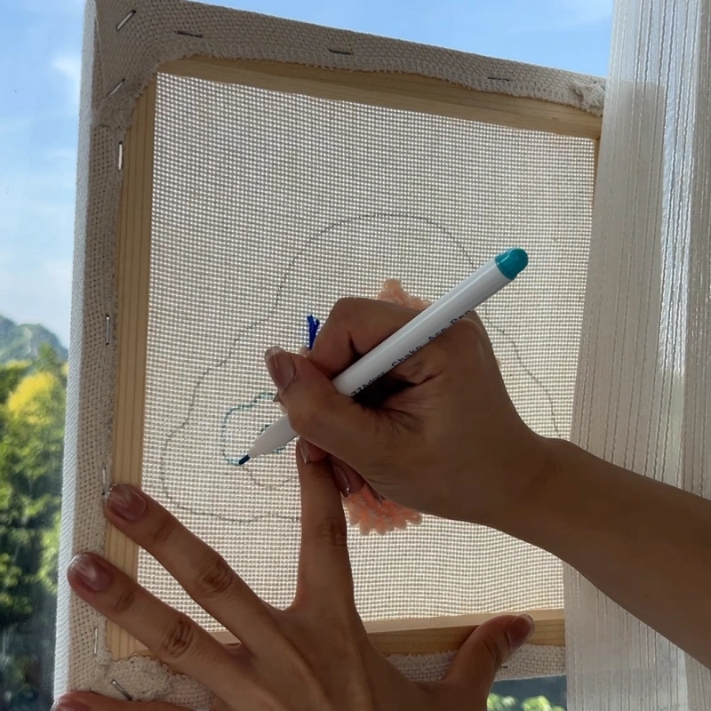 Outlining pattern edges using a water-soluble marking pen for clean design boundaries.