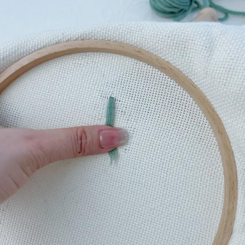 Adjusting the yarn at the needle tip before continuing stitches.