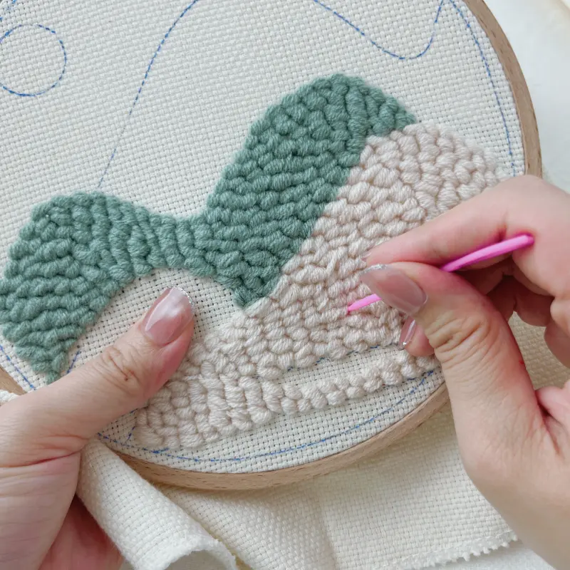 Adjusting uneven yarn loops to create an even surface.