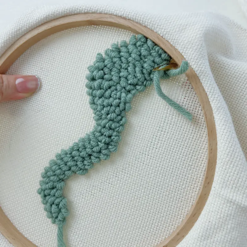 Back view of green block – loops uniform, yarn tail ~3–5 cm left before trimming