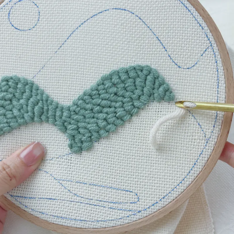 Preparing off-white color block – punch needle threaded with cream yarn next to green wave block