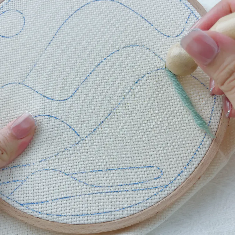 Punching the needle straight down to create the first stitch.