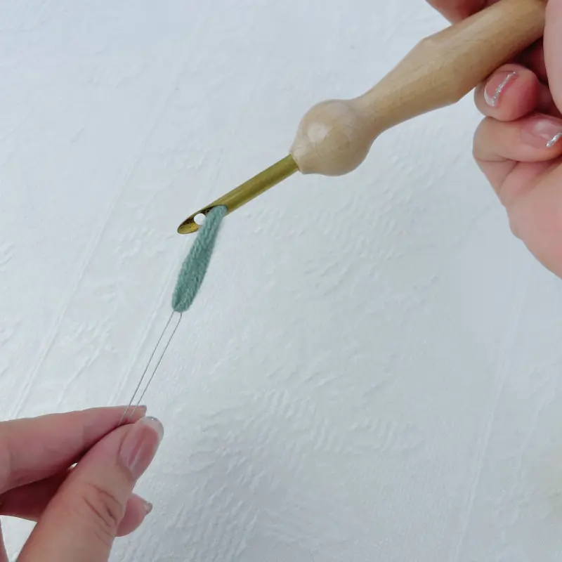 Yarn exiting through the punch needle tip after threading.